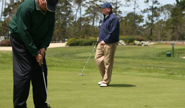 Two older men playing golf